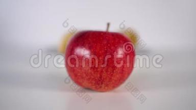 一只手把熟透的红苹果放在白桌上的盘子里的薯片前